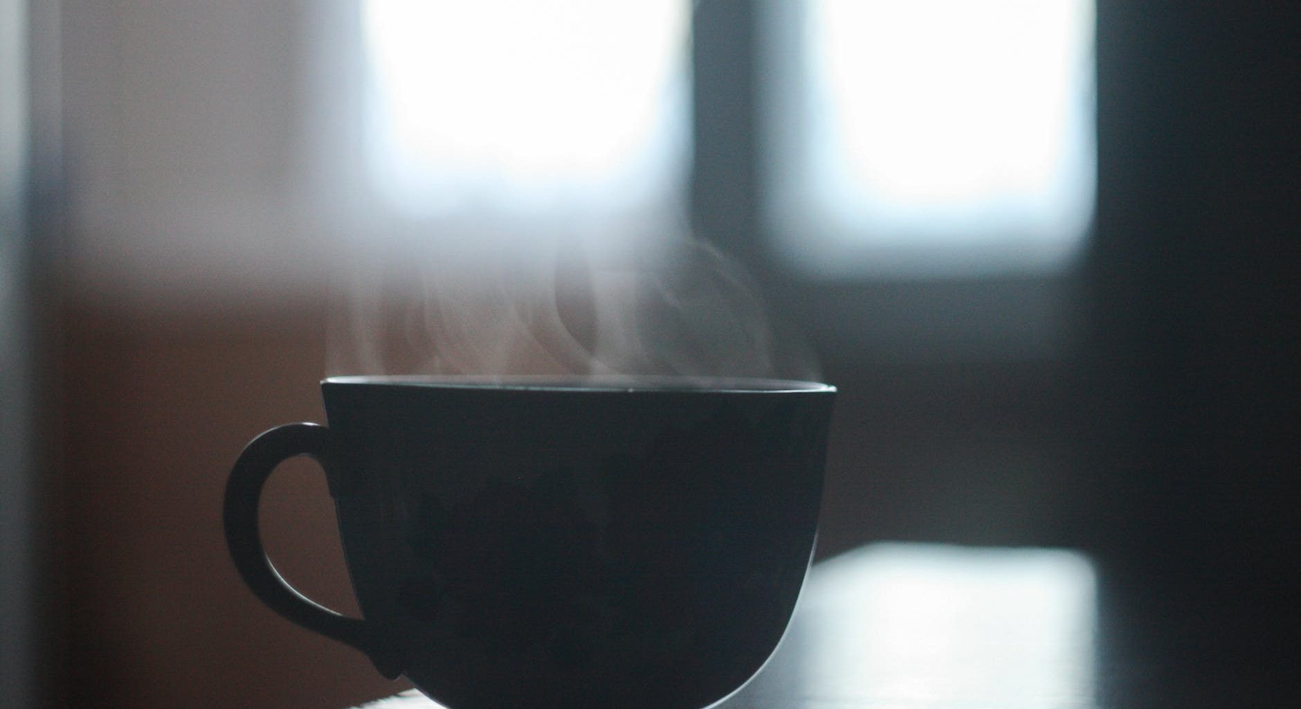 black ceramic cup with smoke above