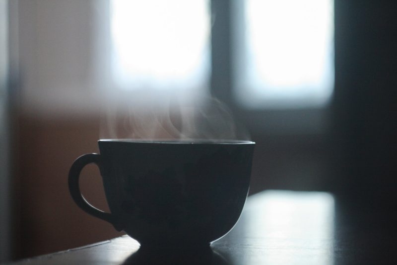 black ceramic cup with smoke above