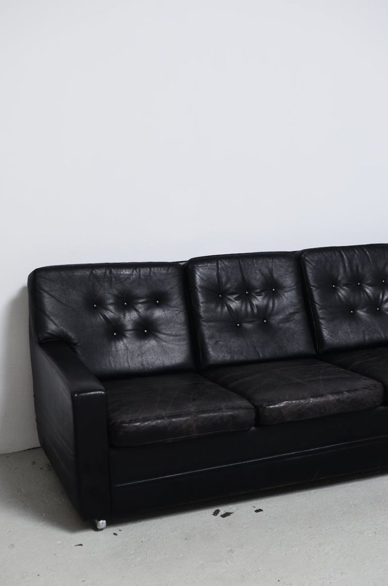 weathered black leather sofa in light room