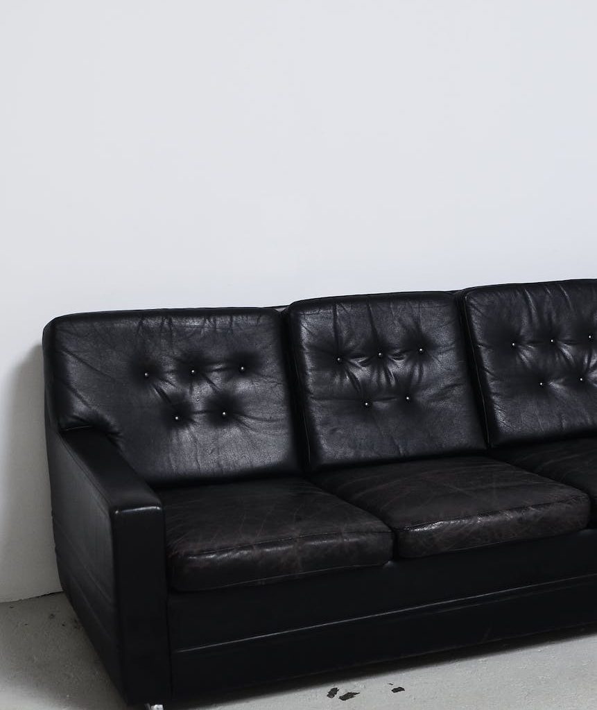 weathered black leather sofa in light room