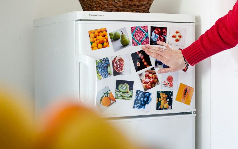a refrigerator with pictures of fruits and vegetables on it